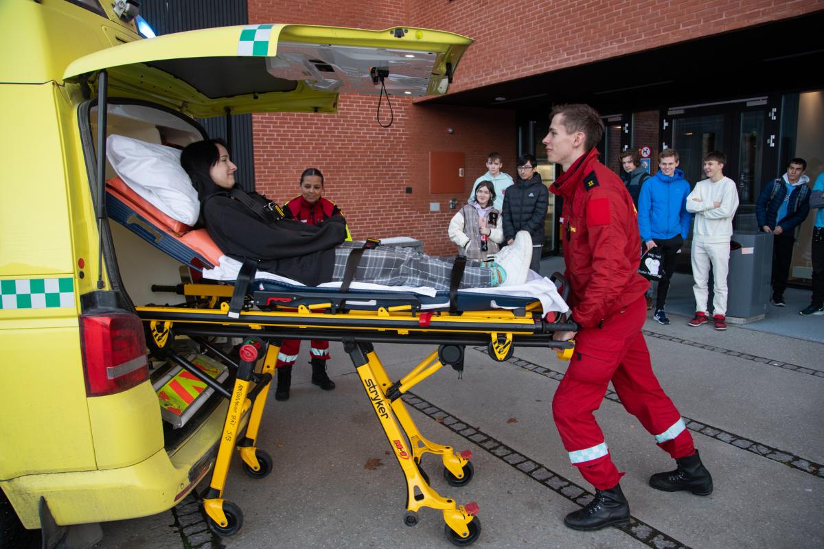 Paramedisin studenter triller en seng inn i sykebilen